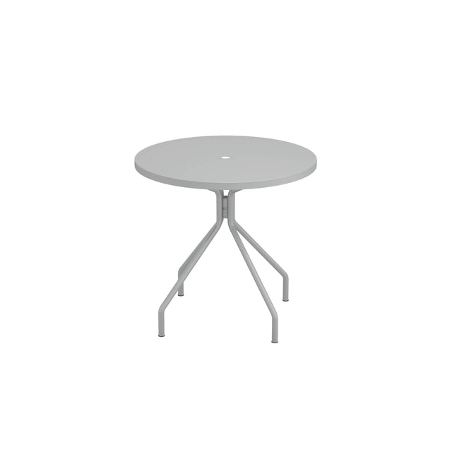 A round, light gray solid steel table with a smooth top and a small center umbrella hole. It has three angled legs extending outward and downward to the floor. This versatile outdoor indoor table stands against a plain white background.