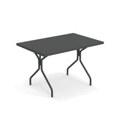 A rectangular black folding table with a smooth surface and sturdy solid steel legs, slightly angled for stability. The minimalist solid steel table is shown against a plain white background.