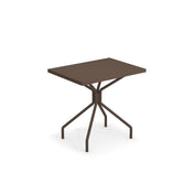A modern, rectangular brown indoor/outdoor table with a flat top and four slender, angled legs that meet at a central point beneath the tabletop, creating a geometric, minimalist design against a white background.