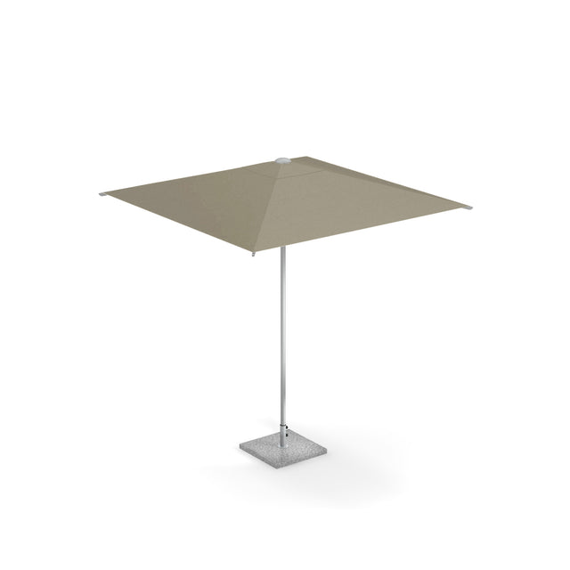 A large, square shade umbrella with a taupe, pocket less canopy is supported by a slim anodized aluminum pole and anchored by a square, textured stone base. The umbrella is open and standing alone against a plain white background.