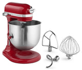 A red KitchenAid Commercial Stand Mixer with a large stainless steel bowl is shown. Three metal attachments—a flat beater, wire whisk, and dough hook—are arranged beside this powerful 8 quart mixer on a white background.