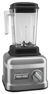 A silver KitchenAid Commercial Bar Blender with a clear 60 oz pitcher, black lid and handle. The base features a numbered speed dial, horizontal start/stop and pulse switches. The pitcher includes durable patented Talon blade metal blades at the bottom.