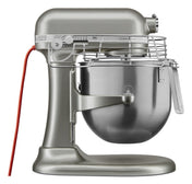 The KitchenAid Commercial Stand Mixer features PowerCore technology and an 8 quart bowl, paired with a robust metallic silver design, safety guard, red power cord, speed control knob, and lever for lifting the bowl—perfect for commercial use.
