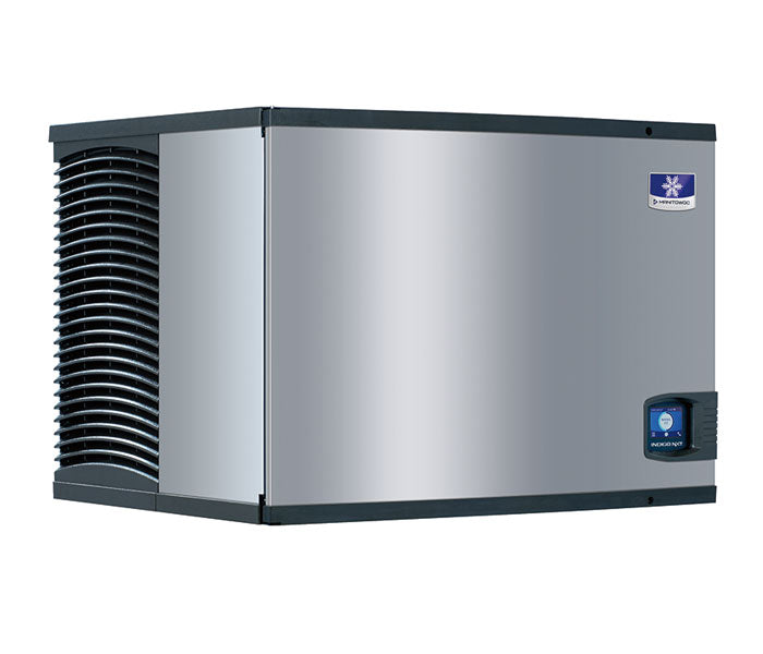 A stainless steel Indigo NXT Series Ice Maker featuring black vents on the left, a blue and white brand logo at the front top right, and a small control panel beneath it. This air-cooled ice machine has a boxy shape and a sleek, modern look.