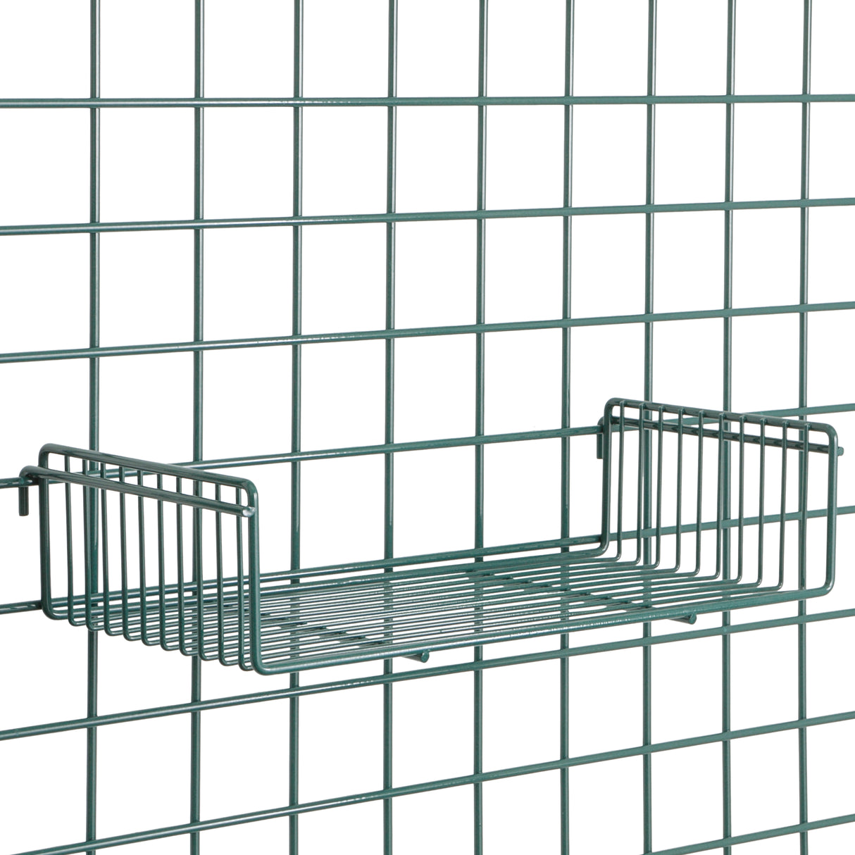 A metal wire grid wall with a Metroseal 3 SmartWall Light-Duty Grid Shelf attached. The rectangular shelf has raised sides, is centered on the green grid, and features minimalist, industrial design with Microban antimicrobial protection.