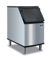 A stainless steel commercial ice bin with a Duratech exterior and four metal legs features a black plastic, top-hinged lid. The front displays a small blue and white manufacturer’s logo near the top right corner, shown against a plain white background.