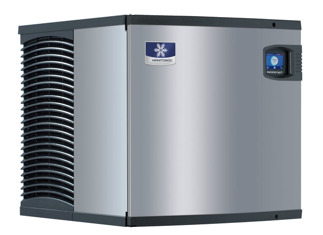 A large, stainless steel Indigo NXT Series Ice Maker commercial ice machine with black side vents and a digital control panel featuring a blue screen. The front displays the blue and white Manitowoc logo. The air-cooled ice maker stands alone on a plain white background.