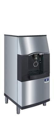 A stainless steel, AHRI certified commercial vending ice dispenser with a black accent panel, angled front, water and ice spouts, and a drip tray beneath. It stands on four short legs and features a blue manufacturer’s logo on the lower right front.