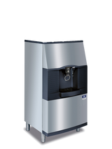 A modern silver and black Vending Ice Dispenser with a touchless lever, dispenser, drip tray, and short legs. The machine features a sleek angular design, digital display above the dispensing area, and metallic surface with black accents.