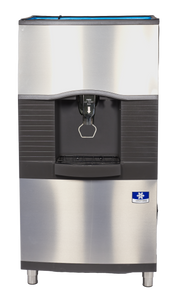 A stainless steel commercial Vending Ice Dispenser with a black panel, push button, and dispensing area. It features a drip tray, blue-and-white manufacturer label, vertical black ridges, and is ideal for ice bucket filling in busy environments.