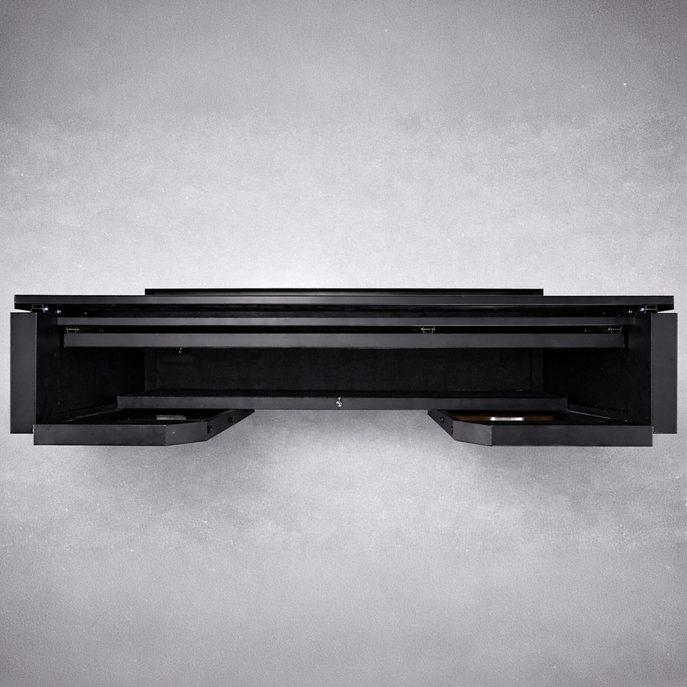 A black, wall-mounted floating desk with two pull-out drawers, viewed from the front against a light gray background. The minimalist design features clean lines, no visible hardware, and complements spaces with a collapsible bar system like the NomadBar Mobile.
