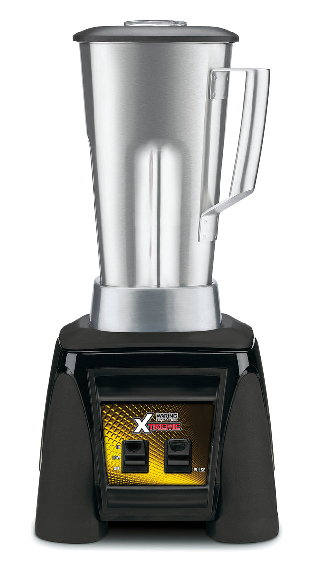 A high-power blender with a 64 oz. stainless steel container, handle, and lid sits on a sturdy black base. The base features a yellow and black “XTREME” label, two switches, and indicator lights. The design is modern and industrial.