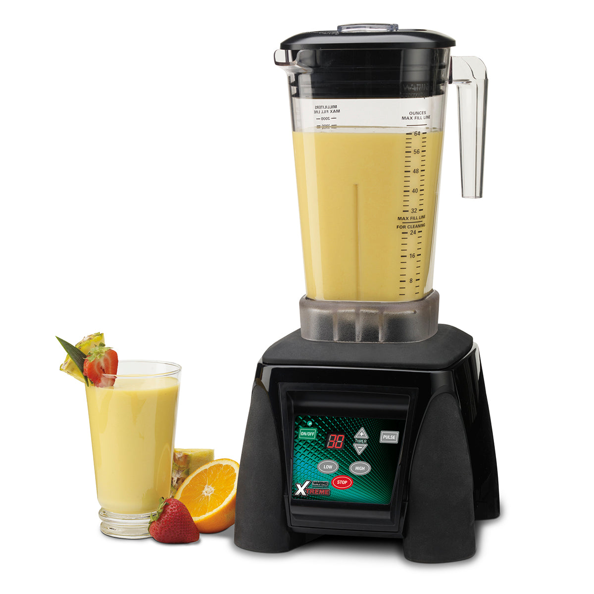 A modern Xtreme Series Blender with a digital touchscreen sits on a white surface. The powerful 3.5 HP blender jar is filled with yellow smoothie, next to a garnished glass and fresh fruit for a vibrant, delicious display.