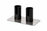 A rectangular metal base supports two upright, black cylindrical holders with U-shaped cutouts on the front. This double Portion Pump Stand by Nemco Food Equipment features evenly spaced holders attached to the brushed silver base, set against a white background.