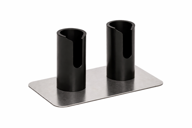 A rectangular metal base supports two upright black cylindrical holders with open side slots. This double Portion Pump Stand by Nemco Food Equipment features evenly spaced holders attached to a flat, brushed metal surface, set against a white background.
