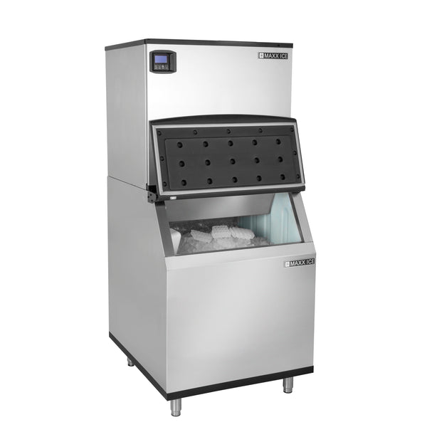 A Maxx Ice commercial stainless steel ice machine with a digital display on top. The upper black door is partly open, revealing ice inside. The lower ice storage bin shows visible ice. This unit, with 580 lbs ice storage, stands on four sturdy legs.