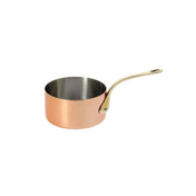 A De Buyer Copper Saucepan with high-end mirror polishing features a shiny silver interior and a long, curved brass handle attached by rivets. Empty and elegant, the pan is angled to the right against a plain white background.