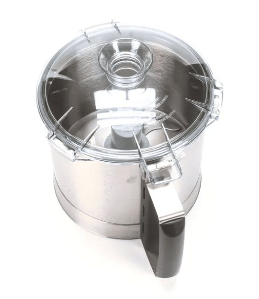 A stainless steel food processor bowl from a cutter bowl kit, with a transparent plastic lid, central feed tube, and large black handle, is shown on a white background. The shiny surface and clear lid are prominently visible from a slightly elevated angle.