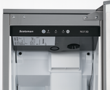 Close-up of the inside upper section of a Scotsman Nugget ice maker, showing the control panel with buttons and indicator lights, a label with information, and part of the white ice bin below. Stainless steel and plastic materials are visible.