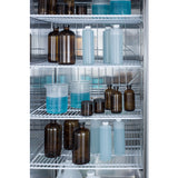 Laboratory refrigerator shelves hold various brown and clear bottles, beakers, and plastic cylinders—some filled with blue or clear liquids. The containers are organized in rows, and the interior of this reach-in refrigerator features metal wire racks for efficient storage.
