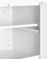 A close-up of an open white metal wall cabinet with two adjustable shelves and a partially open door on the right side, revealing the empty clean interior and visible silver mounting hardware and screws on the sides.