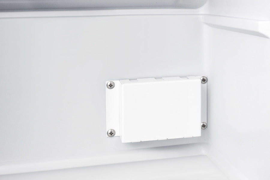A close-up view of the interior wall of a white Accucold medical freezer shows a rectangular plastic cover secured by four screws, one at each corner. The surrounding surface is smooth, with slight shadows highlighting the three-dimensional structure in this compact all-freezer.