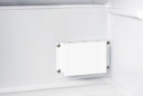 A close-up view of the interior wall of a white Accucold medical freezer shows a rectangular plastic cover secured by four screws, one at each corner. The surrounding surface is smooth, with slight shadows highlighting the three-dimensional structure in this compact all-freezer.