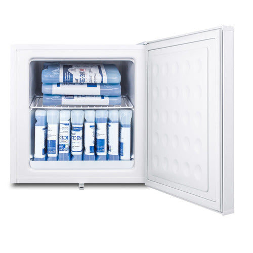 A white compact freezer with its door open displays multiple blue and white gel ice packs neatly stacked on two shelves inside. The interior is clean and empty except for the ice packs; the freezer door has a textured pattern.