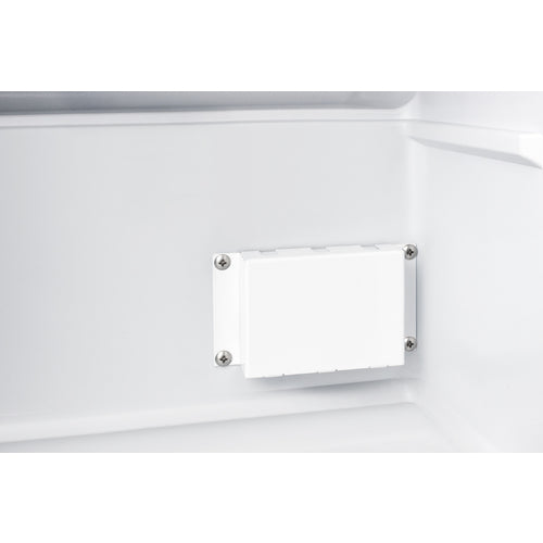 A close-up of a white, rectangular plastic component with four visible screws, mounted on the smooth interior wall of a commercial freezer. The surrounding surface is clean and glossy, suggesting this may be part of a professional or medical freezer setup.