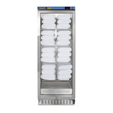 A tall, stainless steel glass-door cabinet holds neatly stacked white towels on four shelves. Using passive heating technology, this blanket warmer ensures towels are always at the perfect temperature. The digital display on the top front panel shows the temperature, while vents at the bottom and a vertical handle on the left side add to its sleek functionality.