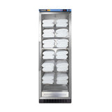 A tall, stainless steel cabinet with a glass door displays neatly folded white towels on adjustable shelves. The cabinet, designed as a blanket warmer, features a digital control panel at the top. The background is plain white.