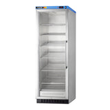 A tall, upright stainless steel commercial refrigerator with a glass door and five adjustable shelves stands empty against a white background. A blue panel with buttons and a display is on top of the door.