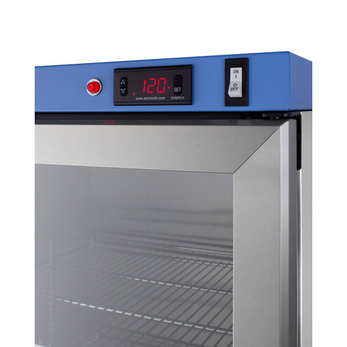 Close-up of a stainless steel medical fridge or blanket warmer door. The blue control panel displays 120 in red LED digits, with arrow buttons, a red button, and an ON/OFF toggle switch. Interior wire shelves are visible through the glass door, illustrating passive heating technology at work.