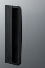 A close-up of a vertical, black, rectangular refrigerator handle mounted on the brushed stainless steel door of a commercial upright freezer, shown against a smooth, gray metallic background.