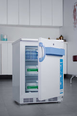 A small white Accucold Medical Freezer with a blue handle stands on a gray floor in a clinic. Its door is open, revealing labeled vaccine boxes and ice packs on glass shelves. This NIST calibrated undercounter all-freezer is complemented by white cabinets and medical supplies visible in the background.