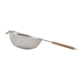 A metal strainer with a double fine mesh basket and a long wooden handle featuring two grips, viewed from the side on a white background. Opposite the handle is a small metal loop for stability when resting on a bowl or pot.