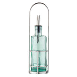 A transparent, light green Gemelli bottle set with stainless steel pourers sits upright in a silver metal holder with a tall, arched handle. The rectangular bottles have soft curves and rest on a white background.