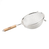 A metal mesh strainer with a fine wire bowl and double medium mesh features a round rim and a long wooden handle. The handle is attached to one side, while a small metal hook on the opposite side helps rest it on a bowl or pot.
