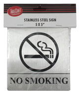 A stainless steel No Smoking sign features a clear symbol—a cigarette with smoke crossed out—and bold NO SMOKING text below. It includes pressure sensitive adhesive for easy mounting and comes in packaging with the TableCraft logo and product details.