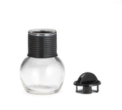 A clear, round glass Hottle with a wide base and a ribbed black plastic neck is shown. Next to it lies a matching lid with a grip knob on a white background. Both the Hottle and lid are dishwasher safe for easy cleaning.