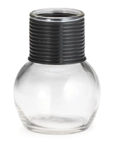 A clear, round glass hottle with a wide base and narrow neck is topped with a thick, textured black plastic collar featuring horizontal grooves. This empty 10 oz container is photographed against a white background.