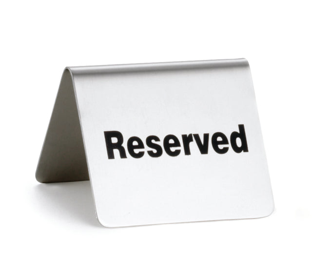A stainless steel buffet tent reserved sign stands on a white surface. The word "Reserved" is boldly printed in black, clearly indicating that the table or space is set aside for someone.