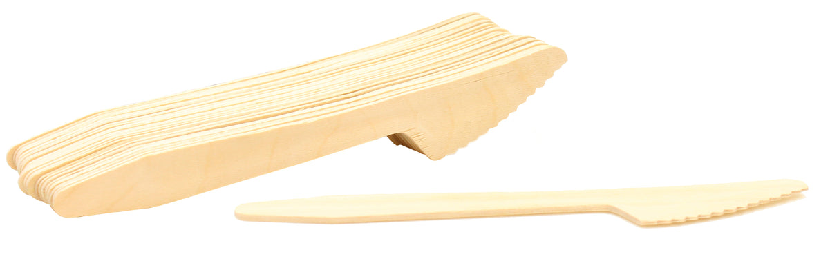 A stack of light-colored pinewood knives is shown with one eco-friendly knife laid separately in front. The knives have a simple, flat design with a serrated edge on one side, all resting on a plain white background.
