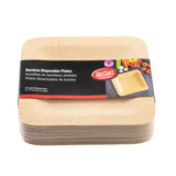 A stack of square TableCraft disposable bamboo plates with rounded edges is wrapped in a black and red label showing the product name in English, French, and Spanish, plus a photo of a plate with vegetables. The 7x7x0.7 size pack includes 25 plates.