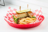 A red basket lined with red and white checkered paper holds a vegan sandwich topped with lettuce and a Vegan Pick, plus golden French fries. The sandwich is partially cut, revealing tomato and lettuce inside a soft bun.