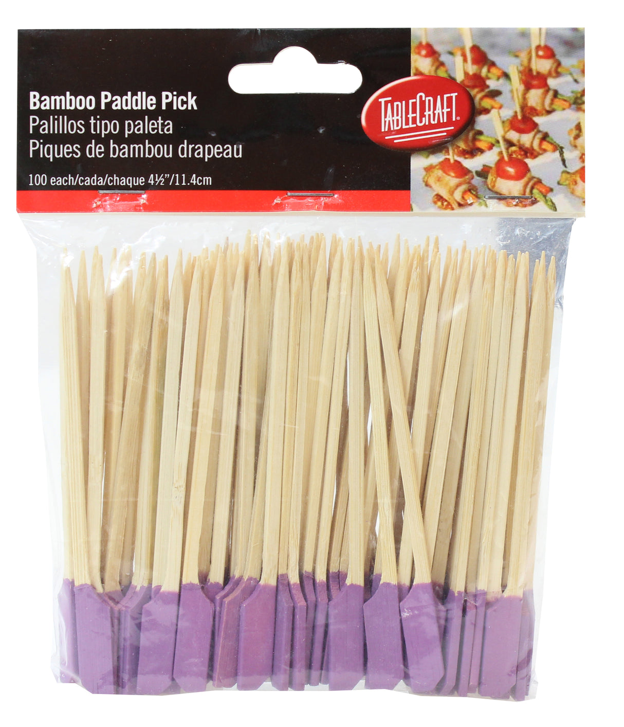 A clear plastic package holds 100 TableCraft bamboo paddle picks with purple cocktail pick ends. The label, in English, Spanish, and French, shows food garnished with the picks and features the TableCraft brand in a red oval.