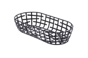 A black powder coated metal serving basket from the Complexity Collection, featuring an oval shape and open grid design with evenly spaced horizontal and vertical strips. It sits on a white background, viewed from a slight angle above.
