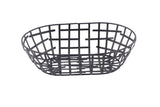 A black powder coated metal Serving Basket from the Complexity Collection, featuring an oval shape and grid-like pattern of crossing strips, photographed on a white background. Its modern design showcases open sides and sturdy construction.