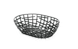 A black powder coated metal Serving Basket with an open geometric grid pattern sits on a white background. Part of the Complexity Collection, its interwoven bars create a modern design and cast subtle shadows beneath it.