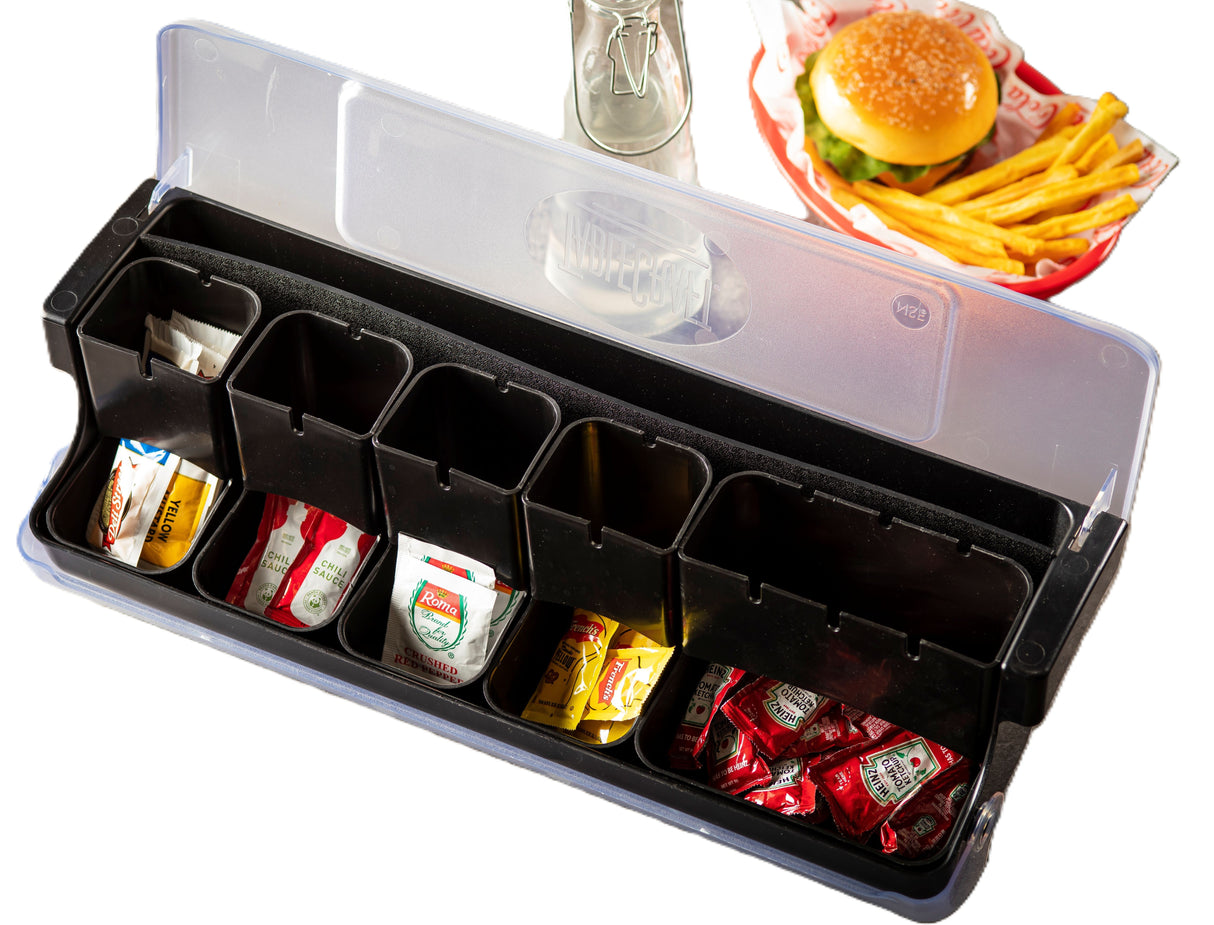 A condiment organizer with six compartments acts as a compact garnish station, holding single-serve ketchup, mustard, and relish packets. The clear-lidded NSF container sits beside a burger and French fries in a basket on a white background.